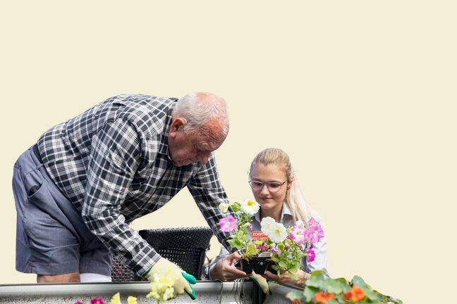 A resident and team member tending flowers together