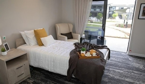 A private bedroom at Wallan with an armchair and garden view